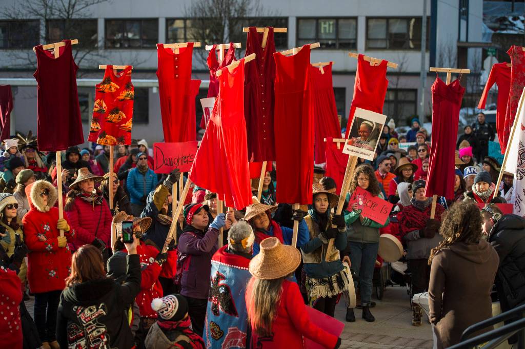 Native women hold up red dresses to symbolize missing and murdered indigenous women during the Womens March on Juneau in front of the Alaska State Capitol on Saturday, Jan. 19, 2019. (Michael Penn | Juneau Empire)