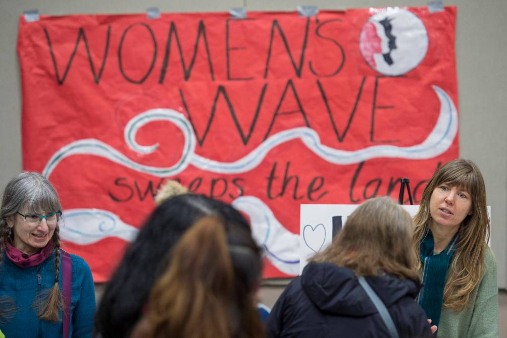 Luann McVey, left, and Julie Nielsen gather signatures for a universal health care letter to be sent to Sen Lisa Murkowski after the Womens March on Juneau at Centennial Hall on Saturday, Jan. 19, 2019. (Michael Penn | Juneau Empire)