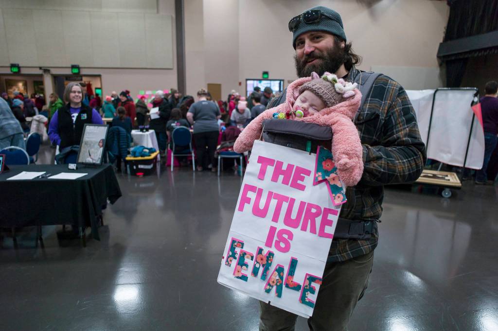 Frank Lambert stops by Centennial Hall with his three-month-old daughter, Frankie, after the Womens March on Juneau on Saturday, Jan. 19, 2019. (Michael Penn | Juneau Empire)