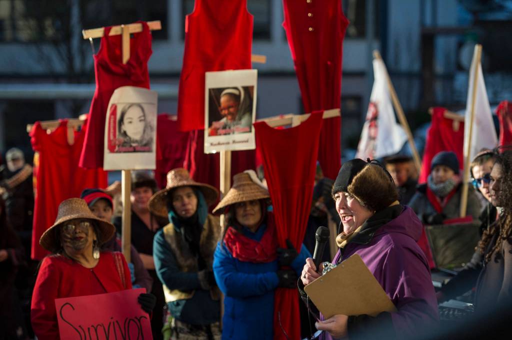 Rep. Sara Hannan speaks as Native women hold up red dresses to symbolizing missing and murdered indigenous women during the Womens March on Juneau in front of the Alaska State Capitol on Saturday, Jan. 19, 2019. (Michael Penn | Juneau Empire)
