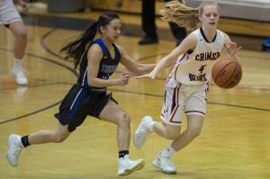 Thunder Mountains Khaye Garcia, left, and Juneau-Douglas Sadie Tuckwood chase down a loose ball at JDHS on Friday, March 3, 2018. JDHS won 53-33. (Michael Penn | Juneau Empire File)