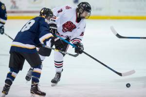 Juneau-Douglas Dalton Hoy, right, moves the puck against Homers Bergen Knutson at Treadwell Arena on Friday, Jan. 18, 2019. JDHS and Homer square off in the ASAA First National Cup state hockey semifinals on Friday in the Curtis Menard Sports Complex in Wasilla. (Michael Penn | Juneau Empire File)