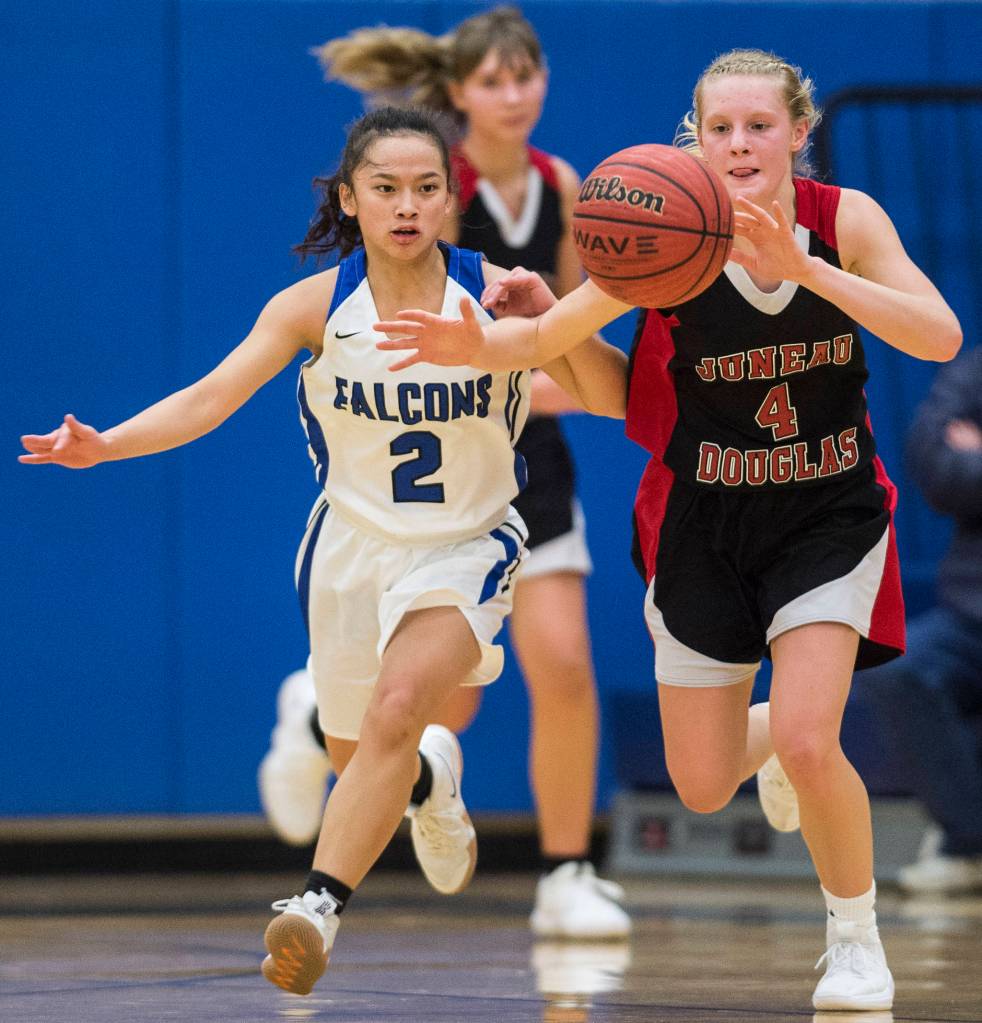Thunder Mountains Mary Khaye Garcia, left, and Juneau-Douglas Sadie Tuckwood chase a loose ball at TMHS on Friday, Feb. 1, 2019. (Michael Penn | Juneau Empire)