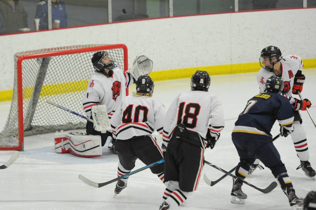 Juneaus Cody Mitchell keeps an eye on the puck as teammates Ethan Welch (40), Dalton Hoy and Blake Bixby look on during the Crimson Bears 3-0 semifinal loss in the Division II state hockey championships Friday, Feb. 1, 2019. (Michael Dinneen | For the Juneau Empire)