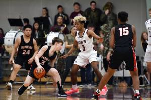 Juneau-Douglas High School junior Austin McCurley works the ball past Ketchikan senior Marcus Lee during a 85-65 Kayhi victory at Clarke Cochrane Gymnasium in Ketchikan on Saturday, Feb. 2, 2019. (Dustin Safranek | Ketchikan Daily News)