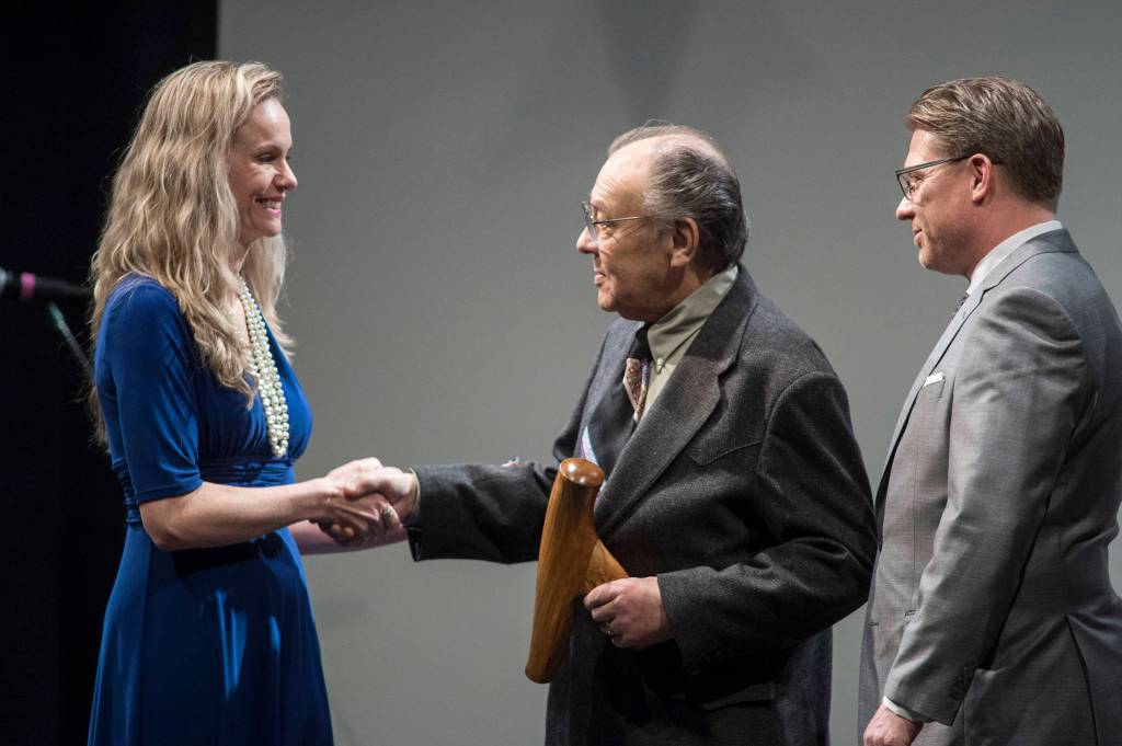Jack Hudson, center, and his son, John Hudson III, of Metlakatla, receive their Alaska Native Arts Award from Kelly Tshibaka, Commissioner of the Department of Administration, at the 2019 Governors Arts and Humanities Awards at the Juneau Arts & Culture Center on Thursday, Feb. 7, 2019. (Michael Penn | Juneau Empire)