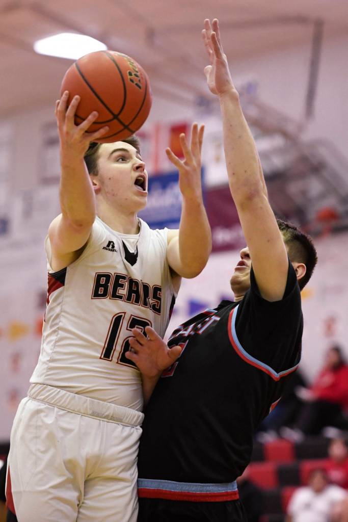 Juneau-Douglas Brock McCormick drives against East Anchorages Aiden Williams at JDHS on Friday, Feb. 8, 2019. East won 66-54. (Michael Penn | Juneau Empire)