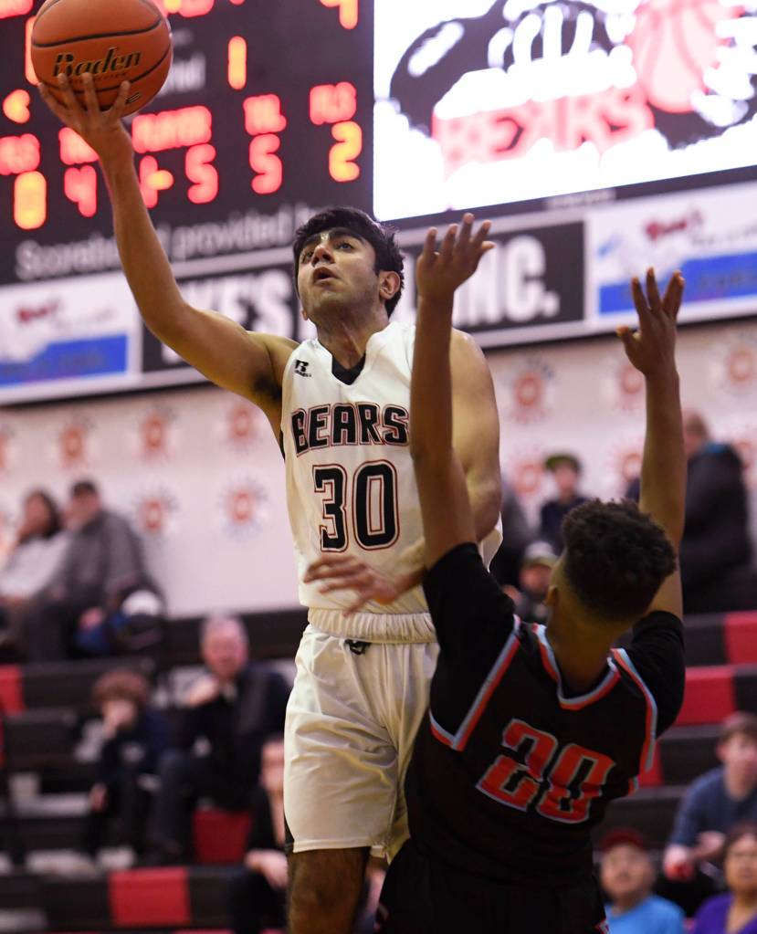Juneau-Douglas Krishant Samtani shoots over East Anchorages Hasani Zimmerman at JDHS on Friday, Feb. 8, 2019. East won 66-54. (Michael Penn | Juneau Empire)