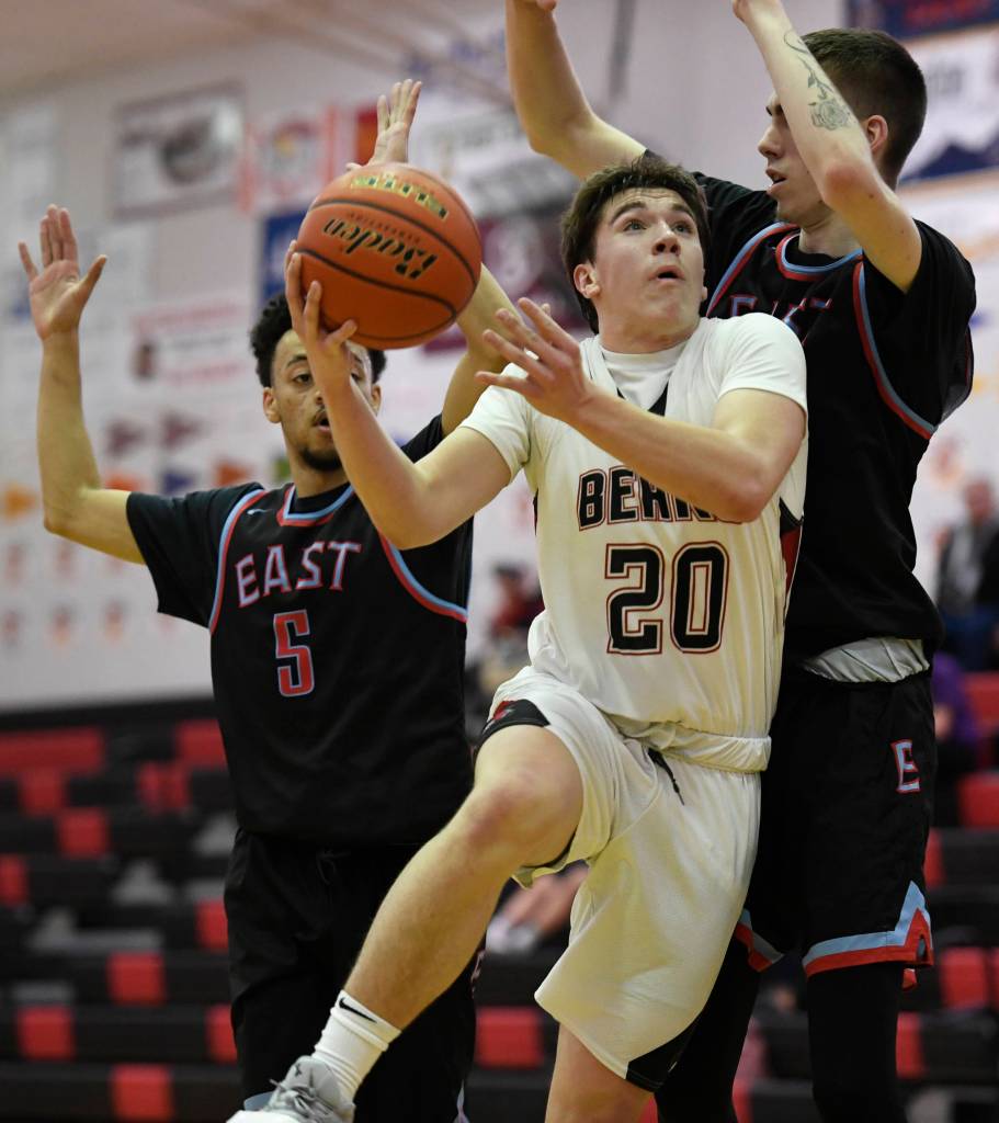 Juneau-Douglas Cooper Kriegmont is challenge inside by East Anchorages Kaeleb Johnson, left, and Andrew Graves at JDHS on Friday, Feb. 8, 2019. East won 66-54. (Michael Penn | Juneau Empire)