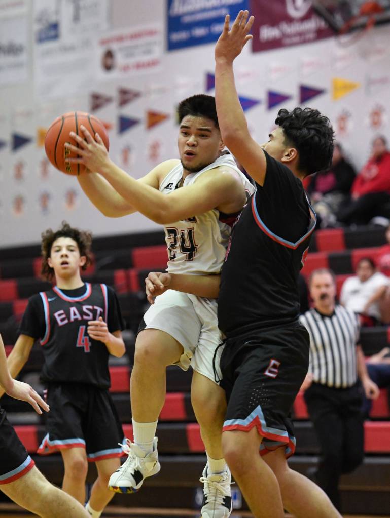 Juneau-Douglas Philip Gonzales pulls in a pass against East Anchorages Nicholas Chichenoff at JDHS on Friday, Feb. 8, 2019. East won 66-54. (Michael Penn | Juneau Empire)