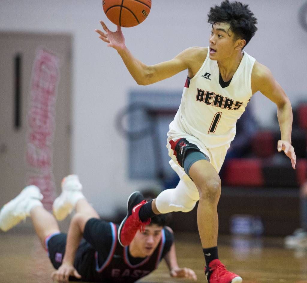 Juneau-Douglas Israel Yadao makes a fast break against East Anchorages Nicholas Chichenoff at JDHS on Friday, Feb. 8, 2019. East won 66-54. (Michael Penn | Juneau Empire)