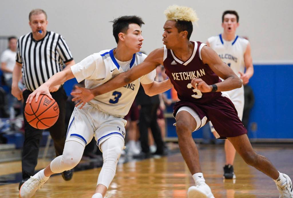 Thunder Mountains Bryson Echiverri, left, evades an attempted steal by Ketchikans Marcus Lee at TMHS on Friday, Feb. 8, 2019. TMHS won 62-55. (Michael Penn | Juneau Empire)
