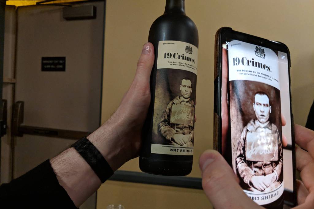 A phone app brings the label of a wine bottle to life at a wine and beer tasting and silent auction benefiting Juneau Animal Rescue at the Westmark Baranof Hotel, Saturday, Feb. 9, 2019. (Ben Hohenstatt | Capital City Weekly)