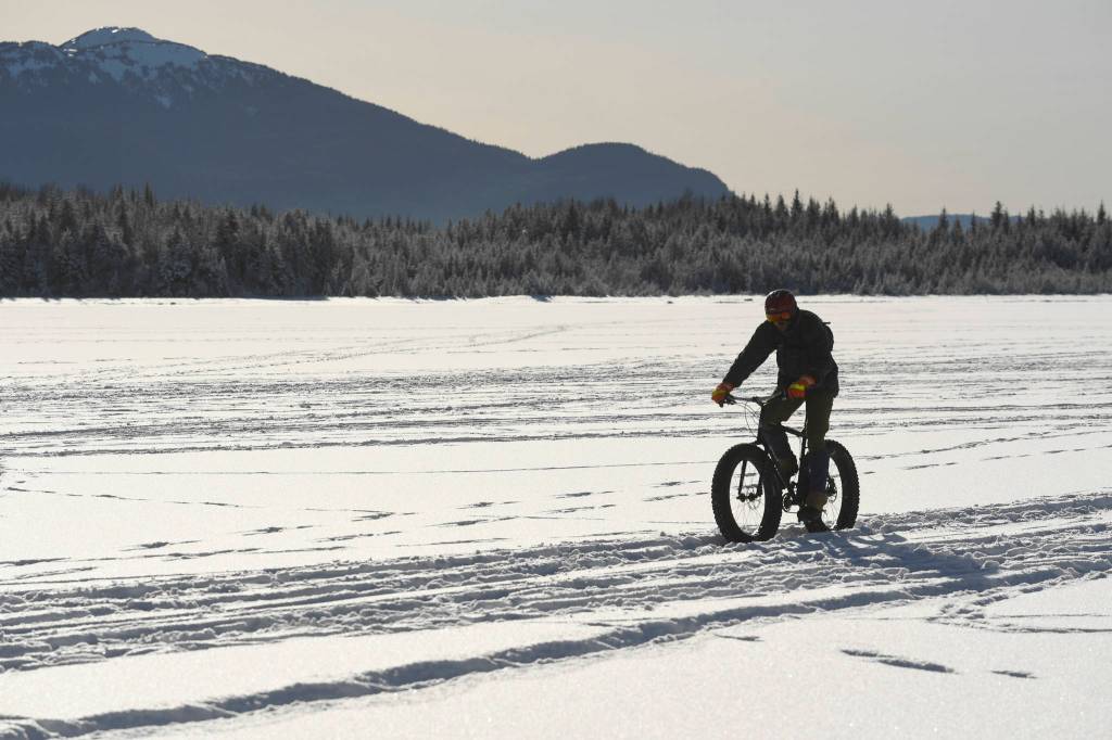 A bicyclist rides across Mendenhall Glacier on Monday, Feb. 11, 2019. (Michael Penn | Juneau Empire)