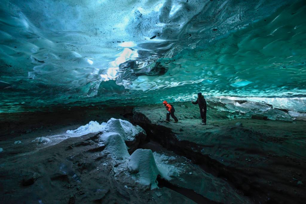 Alexia Keifer and her son, DJ, 8, explore an ice cave at the Mendenhall Glacier on Monday, Feb. 11, 2019. (Michael Penn | Juneau Empire)