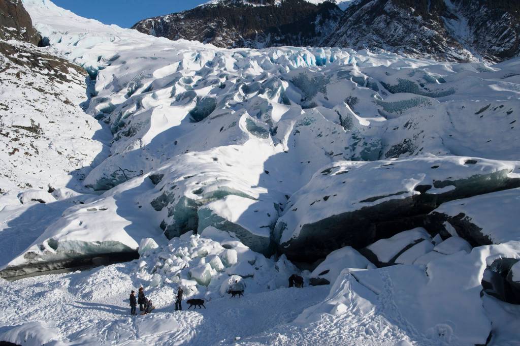 People gather outside the entrance to an ice cave at the Mendenhall Glacier on Monday, Feb. 11, 2019. (Michael Penn | Juneau Empire)