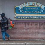 A man with camping gear walks by City Hall on Tuesday, Feb. 12, 2019. Leaders of organizations addressing homelessness have expressed concerns about how state budget cuts will affect their funding for the homeless. (Michael Penn | Juneau Empire)