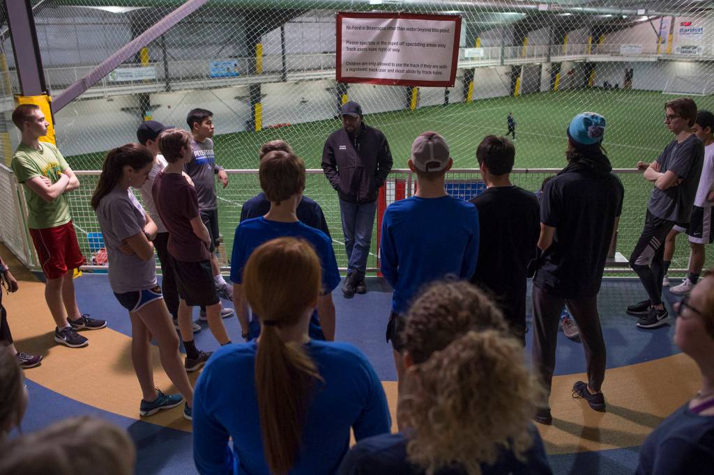 Dwayne Duskin, the new head coach for the Thunder Mountain High School track and field team, talks with students during a pre-season workout at the Wells Fargo Dimond Park Field House on Friday, Feb. 8, 2019. (Michael Penn | Juneau Empire)
