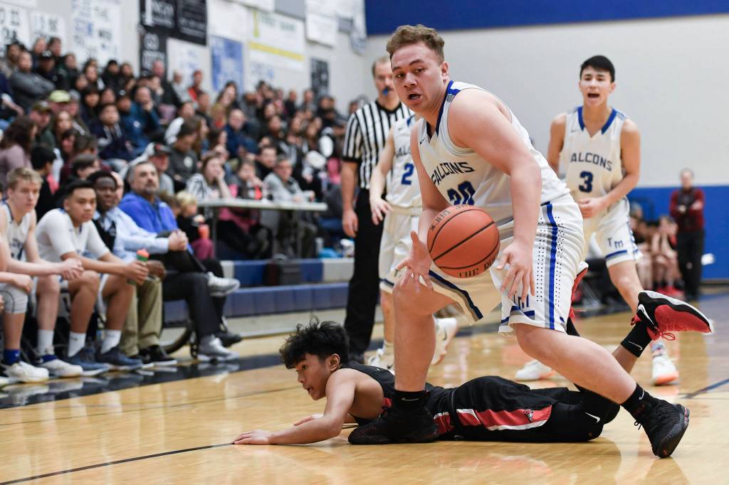 Thunder Mountains Vaipuna Toutaiolepo grabs a loose ball in front of Juneau-Douglas Israel Yadao at THMS on Friday, Feb. 15, 2019. TMHS won 69-59. (Michael Penn | Juneau Empire)