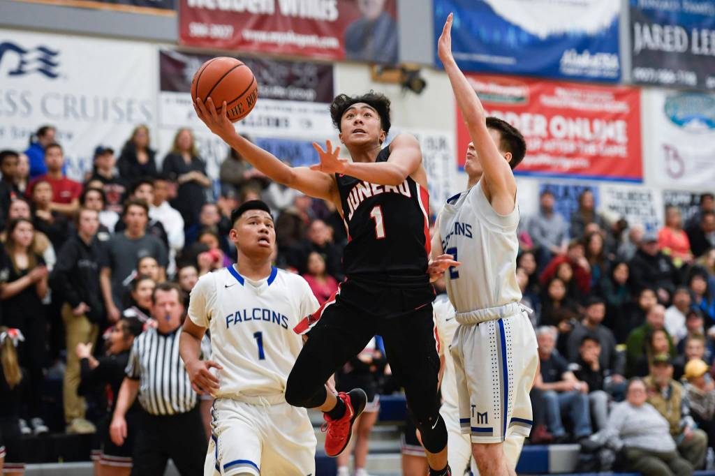 Juneau-Douglas Israel Yadao drives to the basket between Thunder Mountains Brady Carandang, left, and Hansel Hinckle at THMS on Friday, Feb. 15, 2019. TMHS won 69-59. (Michael Penn | Juneau Empire)