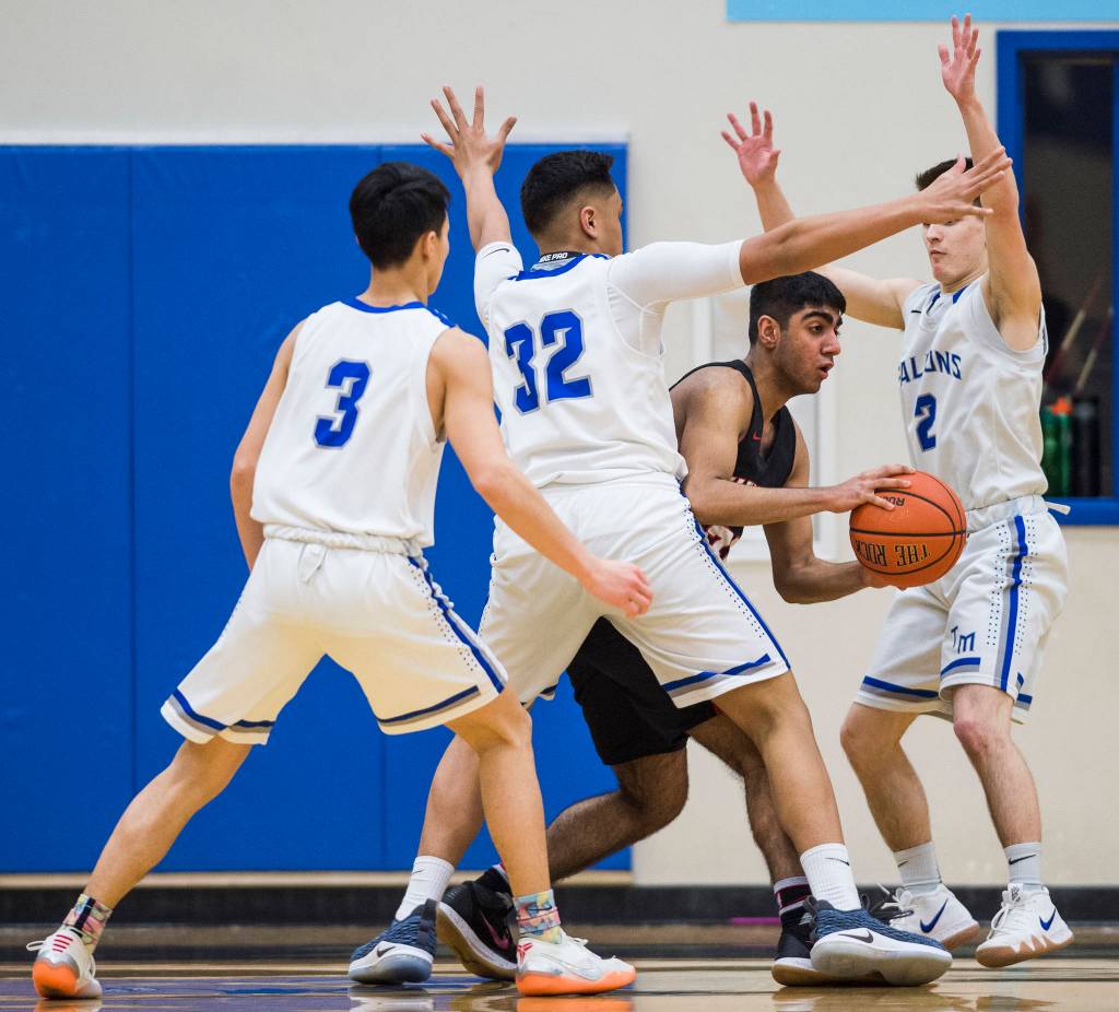 Thunder Mountains Bryson Echiverri, left, Meki Toutaoilepo, center, and Hansel Hinckle, right, pressure Juneau-Douglas Krishant Samtani at THMS on Friday, Feb. 15, 2019. TMHS won 69-59. (Michael Penn | Juneau Empire)