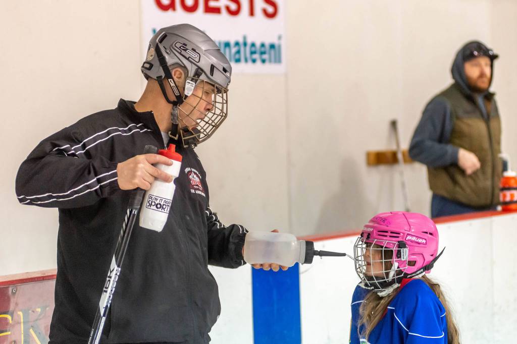 Coach Jim deLabreure helps one of JDIAs youth players enjoy a break during a recent practice at Treadwell Arena. (Courtesy Photo | Steve Quinn)