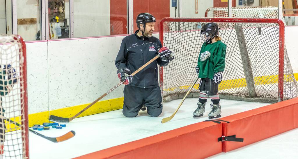 Coach Dan Fabrello shoots a quick smile at a JDIA youth player during a recent practice at Treadwell Ice Arena. (Courtesy Photo | Steve Quinn)