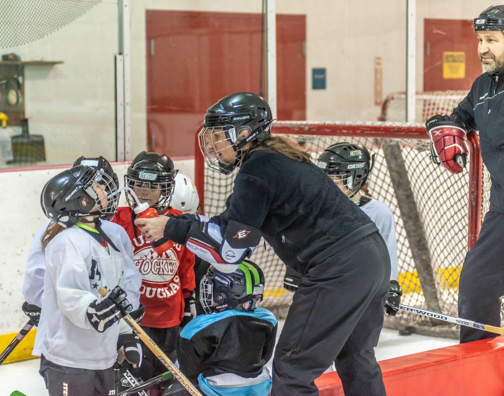 Heather Brandon helps a few players rehydrate during a recent practice at Treadwell Ice Arena. (Courtesy Photo | Steve Quinn)