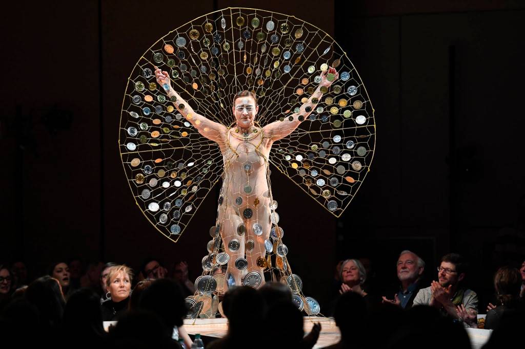 Artist Rhonda Jenkins Gardinier makes her way along the runway in her creation titled Wishes & Prayers in Turbulent Times of wire, wire hangers, tin can ends and fishing swivels at the Wearable Art show at Centennial Hall on Saturday, Feb. 16, 2019. (Michael Penn | Capital City Weekly)