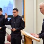 Chief of Police Ed Mercer swears in Jonah Hennings-Booth, of Eagle River, left, and Duain White, of Juneau, center, during a ceremony at the Juneau Police Department station on Thursday, Feb. 21, 2019. (Michael Penn | Juneau Empire)