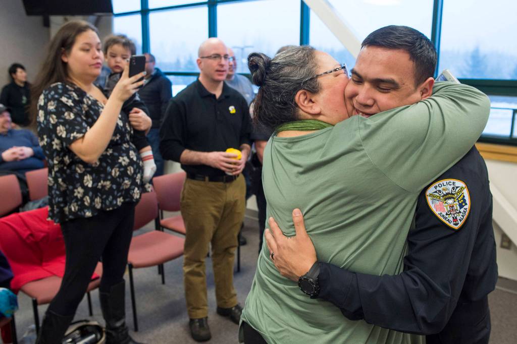 Duain White, of Juneau, receives a long hug by his aunt Amy Starbard after he was sworn in as a new officer during a ceremony at the Juneau Police Department station on Thursday, Feb. 21, 2019. (Michael Penn | Juneau Empire)