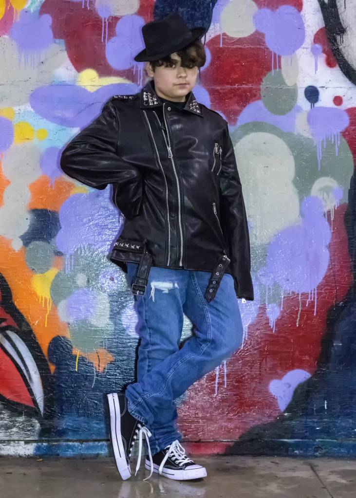 March 10, 2019: I met 11-year-old Joel Price one evening at The Pipeline skate park. Joel has a great attitude and demonstrates that a single piece of clothing can define a certain look. His faux black leather jacket with silver studs was the definite focal point of his outfit. Add in a black felt fedora, black T-shirt, Hollister button-fly jeans and canvas tennis shoes to complete the look.