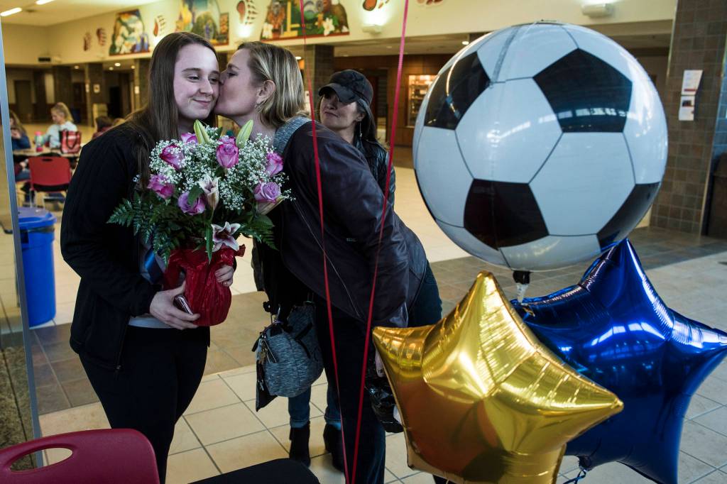 Senior Shaylin Cesar receives balloons, flowers and a kiss from her mother, Nancy, as she gets ready to sign a national letter of intent on Monday, Feb. 25, 2019, at Juneau-Douglas High School: Yadaa.at Kalé to play soccer at Montana State University Billings next year. (Michael Penn | Juneau Empire)