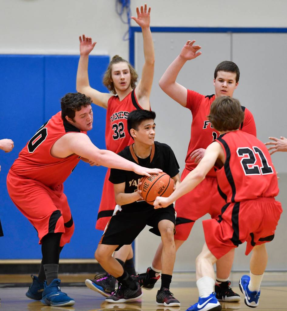Yakutats Jerry Ridington, center, finds himself surrounded by Gustavuss David Blaine, left, Jacob Patrick, Daniel Bohike and Skyler Glenn Region V 1A Basketball Championships at Thunder Mountain High School on Wednesday, Feb. 27, 2019. Gustavus won 40-39.(Michael Penn | Juneau Empire)
