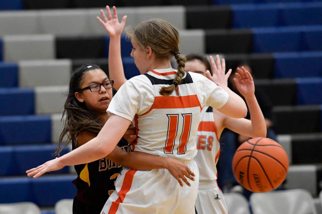 Hoonahs Cheyenne Jack passes the ball behind Yakutats Jessica Holcomb at the Region V 1A Basketball Championships at Thunder Mountain High School on Thursday, Feb. 28, 2019. Hoonah won 33-16. (Michael Penn | Juneau Empire)