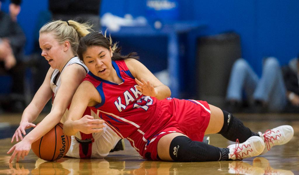 Klawocks Kenai Holien, left, dives for the ball against Kakes Courtney James in the finals of the Region V 1A Basketball Championships at Thunder Mountain High School on Friday, March 1, 2019. Klawock won 47-46. (Michael Penn | Juneau Empire)