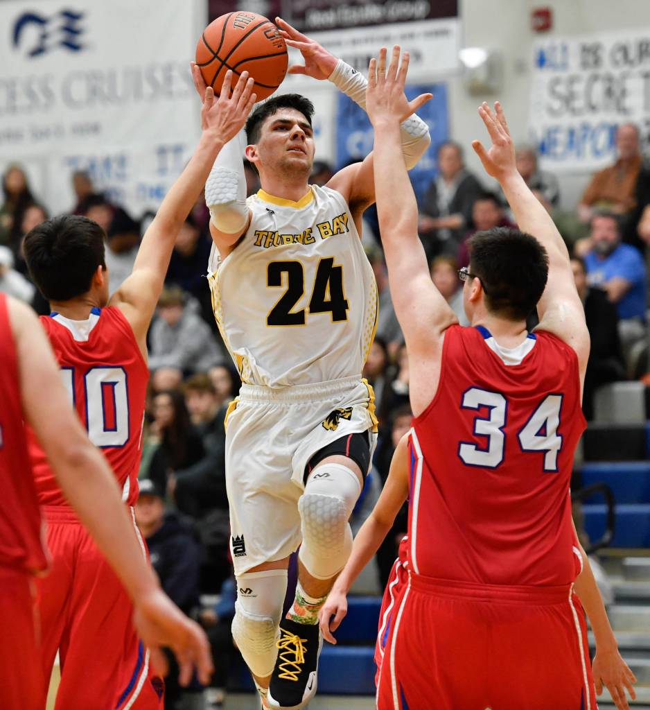 Thorne Bays Jacob Congdon shoots over Kakes Nicholas Davis, left, and Luke Hanson in the final of the Region V 1A Basketball Championships at Thunder Mountain High School on Friday, March 1, 2019. Thorne Bay won 55-44. (Michael Penn | Juneau Empire)