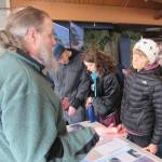 Eric Ouderkirk, left, Alaska Region regional landscape architect for the U.S. Forest Service, talks with Juneau resident Justine Muench, far right, in the Mendenhall Glacier Visitor Center, Saturday, March 2, 2019. (Ben Hohenstatt | Juneau Empire)