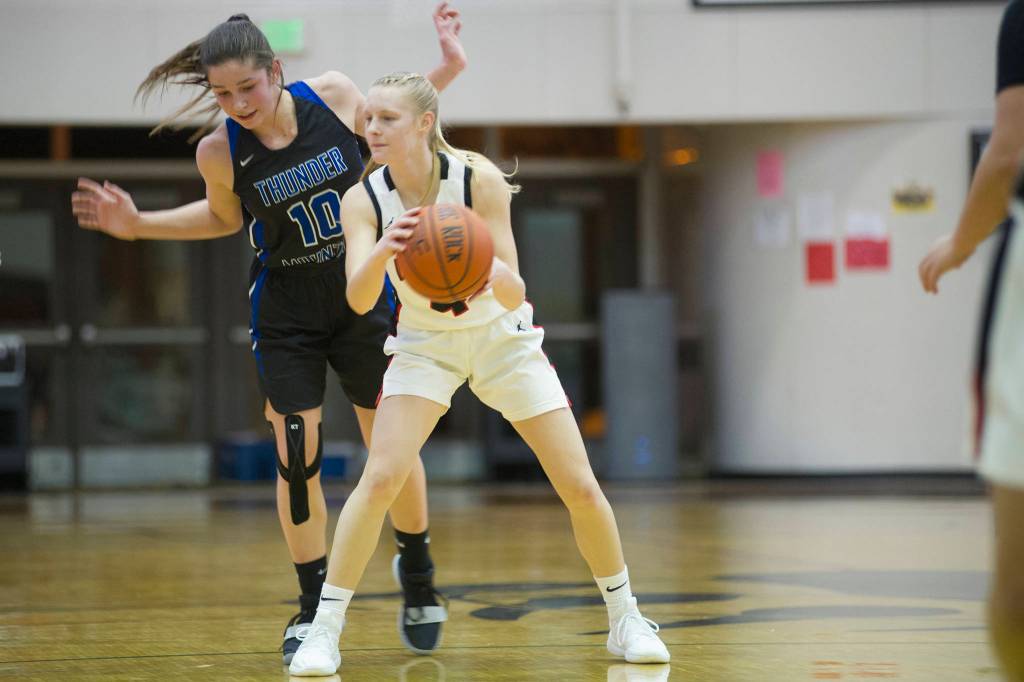 Thunder Mountains Riley Traxler gets out of the way of Juneau-Douglas Sadie Tuckwood in their game at JDHS on Saturday, March 2, 2019. (Nolin Ainsworth | Juneau Empire)