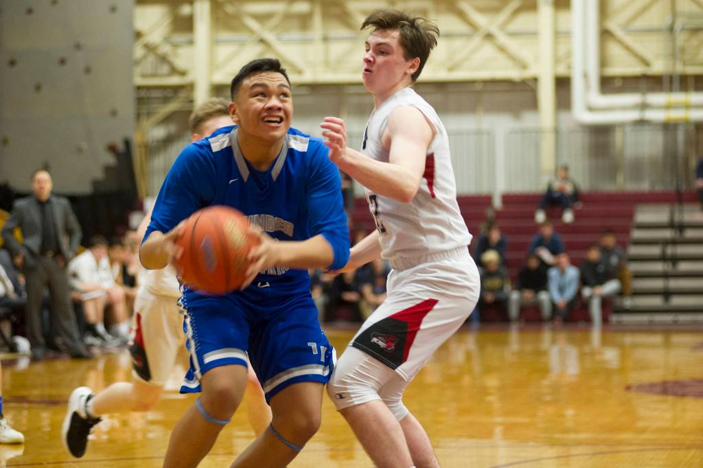 Thunder Mountains Meki Toutaiolepo prepares to shoot over Juneau-Douglas Brock McCormick in the Region V Basketball Tournament at B.J. McGillis Gymnasium in Sitka on Thursday, March 7, 2019. (Nolin Ainsworth | Juneau Empire)