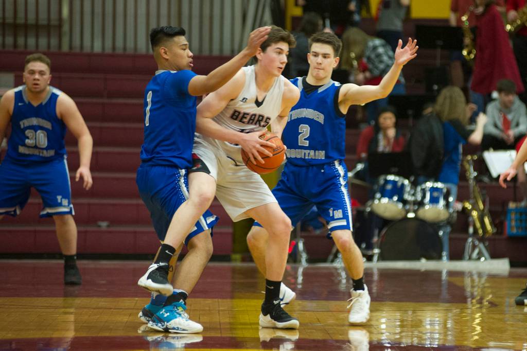 Juneau-Douglas Tristan Bryant is closely guarded by Thunder Mountains Brady Carandang, left, and Hansel Hinckle, right, in the Region V Basketball Tournament at B.J. McGillis Gymnasium in Sitka on Thursday, March 7, 2019. (Nolin Ainsworth | Juneau Empire)