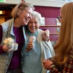Margie Beedle, left, hugs her mother, Sally Thibodeau, as they chat with Alaska Pioneer Home employee Laura Minne during the homes weekly ice cream social on Friday, March 8, 2019. (Michael Penn | Juneau Empire)