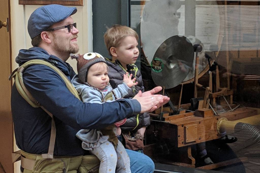Andy Mills and his children, 1-year-old Eden, and 3-year-old Malcolm, applaud during a Kimball pipe organ concert, Friday, March 15, 2019. (Ben Hohenstatt | Capital City Weekly)