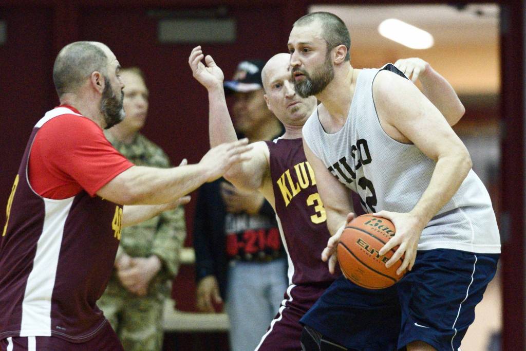 Filcoms Ray Zimmer, right, is pressured under the basket by Klukwans Brian Friske, center, and Stuart DeWitt in their C bracket game at the Lions Clubs Gold Medal Basketball Tournament on Thursday, March 21, 2019.