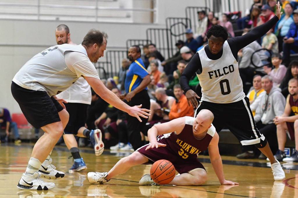 Klukwans Brian Friske, center, goes for a loose ball against Filcoms Greg Lockwood, left, and Rob Ridgeway in their C bracket game at the Lions Clubs Gold Medal Basketball Tournament on Thursday, March 21, 2019. (Michael Penn | Juneau Empire)