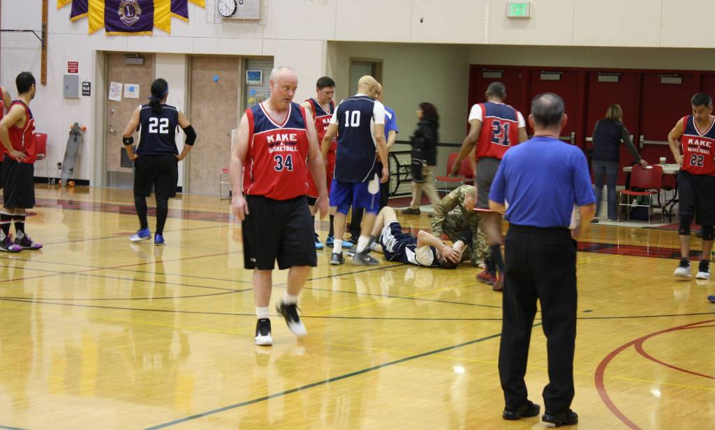 An injured Angoon player holds his head during the second quarter of a Gold Medal Tournament game against Kake, Monday, March 18, 2019.