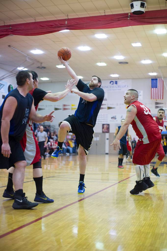 Hydaburgs Eric Hamilton drives to the basket as Hoonahs Jeremy Martin looks on in their C bracket game at the Lions Club Gold Medal Basketball Tournament on Thursday, March 21, 2019. (Nolin Ainsworth | Juneau Empire)
