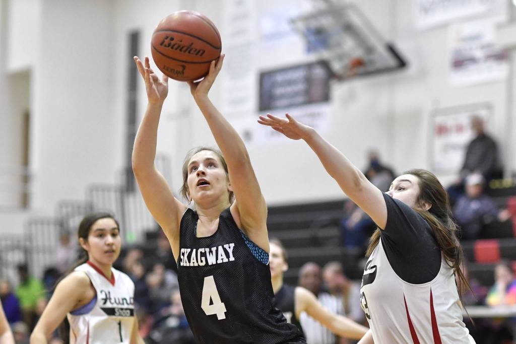 Skagways Kaitlyn Jerod shoots between Hoonahs Melissa Fisher, left, and Mariah Martin in the match at the Lion Club Gold Medal Basketball Tournament on Tuesday, March 19, 2019. (Michael Penn | Juneau Empire)