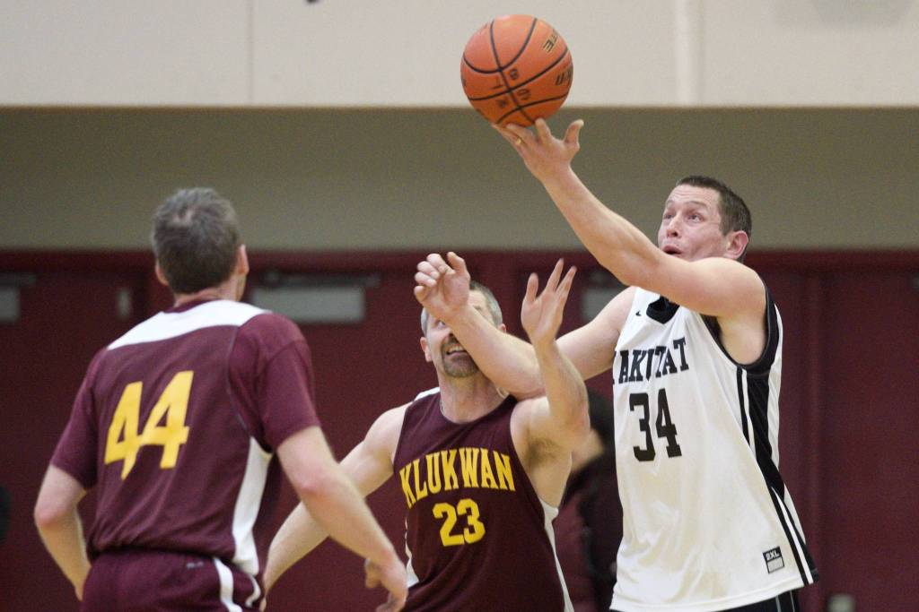 Yakutats Jimmi Jensen, right, rebounds over Klukwans Michael Ganey, center, in their match at the Lion Club Gold Medal Basketball Tournament on Tuesday, March 19, 2019. (Michael Penn | Juneau Empire)