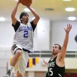 Klukwans Austin Shoemaker lays the ball up over Haines Brian Combs in a B bracket game at the Juneau Lions Club 73rd Annual Gold Medal Basketball Tournament at Juneau-Douglas High School: Yadaa.at Kalé on Tuesday, March 19, 2019. Haines won 97-51. (Michael Penn | Juneau Empire)
